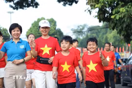 Người dân Tuyên Quang đồng loạt khoác lên mình áo đỏ sao vàng, hát Quốc ca và cùng tiến bước vì một Việt Nam đoàn kết. (Ảnh: Quang Cường/TTXVN)