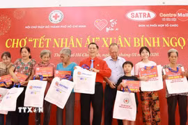 Đại diện Hội Chữ thập đỏ Thành phố Hồ Chí Minh tặng quà cho các gia đình khó khăn tại sự kiện Chợ Tết Nhân ái Xuân Bính Ngọ 2026. (Ảnh: Đinh Hằng/TTXVN)