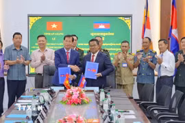 Ban chuyên trách 2 tỉnh ký kết biên bản bàn giao, tiếp nhận hài cốt liệt sỹ. (Ảnh: TTXVN phát)