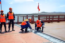 Lễ hợp long cây cầu đường bộ bắc qua sông Tumannaya kết nối Nga-Triều Tiên. (Ảnh: AFP)