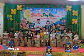 Các cựu chiến binh TTXVN tặng quà cho học sinh Trường mầm non Hưng Khánh Trung. (Ảnh: Huỳnh Phúc Hậu/TTXVN)