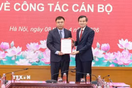PGS.TS Đoàn Minh Huấn, Ủy viên Bộ Chính trị, Giám đốc Học viện Chính trị quốc gia Hồ Chí Minh trao Quyết định của Ban Bí thư về việc bổ nhiệm Trợ lý đối với đồng chí Nguyễn Quốc Sửu - Trợ lý PGS.TS Đoàn Minh Huấn, Ủy viên Bộ Chính trị, Giám đốc Học viện Học viện Chính trị quốc gia Hồ Chí Minh. (Ảnh: TTXVN phát)