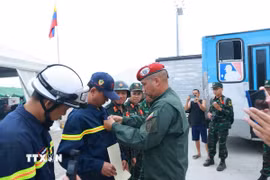Trung tá Raúl Serrano Chacón gắn uy chương cho thành viên đoàn Việt Nam. (Ảnh: Phi Hùng/TTXVN)