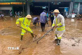 Lực lượng Cảnh sát giao thông, Công an Sơn La nạo bùn, khơi thông cống rãnh do mưa lớn kéo dài xảy ra tại xã Mường La. (Ảnh: TTXVN phát)