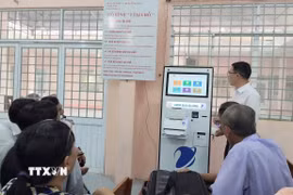 Cán bộ Trung tâm Phục vụ hành chính công xã Phú Lâm (tỉnh An Giang) hướng dẫn người dân các thao tác gửi, kiểm tra hồ sơ thủ tục hành chính bằng kiốt thông minh. (Ảnh: Công Mạo/TTXVN)