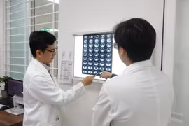 Bác sỹ thăm khám bệnh nhân sau khi được phẫu thuật loại bỏ khối u mỡ. (Ảnh: TTXVN phát)