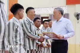 Phó Thủ tướng Thường trực Nguyễn Hòa Bình trao Giấy chứng nhận đặc xá cho những người được đặc xá ở Trại giam A2. (Ảnh: Tiên Minh/TTXVN)