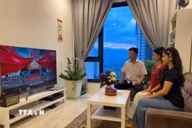 Gia đình anh Lê Văn Hùng xem truyền hình trực tiếp buổi lễ kỷ niệm 50 năm Ngày Giải phóng miền Nam, thống nhất đất nước. (Ảnh: Hằng Linh/TTXVN)