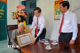 Ông Đoàn Minh Huấn, Ủy viên Bộ Chính trị, Giám đốc Học viện Chính trị Quốc gia Hồ Chí Minh trao chứng nhận 80 năm tuổi Đảng cho đảng viên Phạm Duy Khương. (Ảnh: Thanh Liêm/TTXVN)