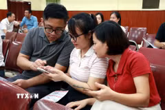 Người dân cài đặt, sử dụng các tính năng của Ứng dụng Công dân số NinhBinh-S. (Ảnh: Nguyễn Lành/TTXVN)