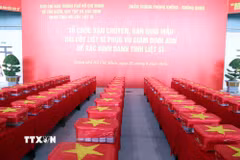 Các mẫu sinh phẩm hài cốt liệt sỹ được niêm phong, đóng gói nghiêm ngặt vào thùng chuyên dụng, phủ Quốc kỳ trước khi được đưa lên máy bay. (Ảnh: Xuân Khu/TTXVN)