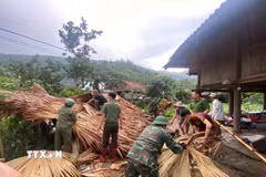 Chính quyền địa phương và các lực lượng chức năng hỗ trợ người dân Dương Quỳ khắc phục hậu quả thiên tai. (Ảnh: TTXVN phát)