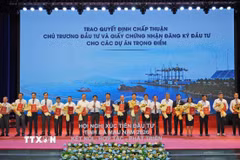 Lãnh đạo Ủy ban Nhân dân tỉnh Cà Mau trao quyết định chấp thuận chủ trương đầu tư và giấy chứng nhận đăng ký đầu tư cho các dự án trọng điểm. (Ảnh: Huỳnh Anh/TTXVN)