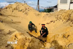 Với sự hỗ trợ của Bộ Chỉ huy Quân sự tỉnh Quảng Trị, lực lượng chức năng tiến hành khảo sát, xử lý di dời an toàn quả bom theo đúng quy định. (Ảnh: TTXVN phát)
