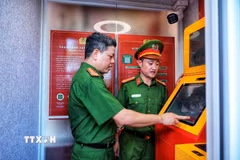 Thượng tá Nguyễn Thành Lâm (bên trái) cùng cán bộ Công an trải nghiệm hoạt động của Kiosk “Trạm Cảnh sát thông minh” trước khi đưa vào phục vụ người dân. (Ảnh: Phạm Tuấn Anh/TTXVN)
