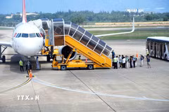 Hành khách xếp hàng lên máy bay tại Cảng hàng không Đồng Hới (Quảng Trị). (Ảnh: Tá Chuyên/TTXVN)