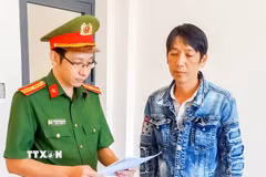 Cơ quan Cảnh sát điều tra Công an thành phố Cần Thơ tống đạt các quyết định với đối tượng Trương Văn Công. (Ảnh: TTXVN phát)