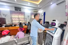 Robot thông minh tích hợp AI hỗ trợ người dân tra cứu thủ tục và lấy số thứ tự tại Trung tâm Phục vụ hành chính công xã. (Ảnh TTXVN phát)