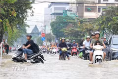 Triều cường gây ngập sâu khiến việc di chuyển của người dân rất khó khăn. (Ảnh minh họa: TTXVN phát)