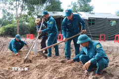 Lực lượng chức năng tìm kiếm hài cốt liệt sỹ khu vực Gò Tràm, thôn An Sơn. (Ảnh: Phạm Cường/TTXVN)