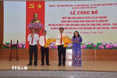 Lãnh đạo thành phố Cần Thơ trao quyết định công nhận xã An toàn khu cho lãnh đạo xã Cờ Đỏ. (Ảnh: Thu Hiền/TTXVN)