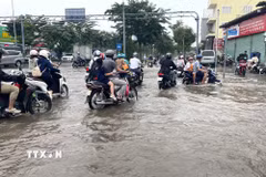 Nhiều phương tiện di chuyển khó khăn do triều cường trên đường Nguyễn Lương Bằng, thành phố Hồ Chí Minh, ngày 6/11/2025. (Ảnh: Hương Giang/TTXVN)