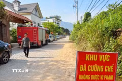 Lực lượng chức năng thiết lập khu vực cưỡng chế, bố trí phương tiện phòng cháy, chữa cháy và bảo đảm an toàn tại hiện trường. (Ảnh: Trung Nguyên/TTXVN)