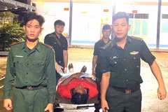 Bộ đội Biên phòng Cà Mau hỗ trợ thuyền viên bị thương ở chân lên xe về tỉnh Kiên Giang. (Ảnh: TTXVN phát)