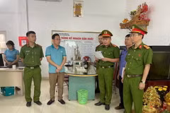 Công an thành phố Thanh Hóa thi hành Quyết định khởi tố vụ án, khởi tố bị can đối với Hoàng Văn Cường-áo xanh. (Ảnh: TTXVN phát)