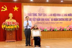 Phó Bí thư Thường trực Tỉnh ủy, Chủ tịch HĐND tỉnh Quảng Trị Nguyễn Đăng Quang trao danh hiệu "Bà mẹ Việt Nam Anh hùng” cho bà Lê Thị Mót, xã Gio Sơn, huyện Gio Linh. (Ảnh: Nguyên Lý/TTXVN)
