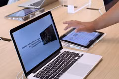 Khách hàng trải nghiệm máy tính MacBook tại cửa hàng của Apple tại Rosny-sous-Bois, gần Paris, Pháp. (Ảnh: AFP/TTXVN)