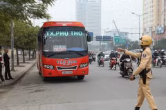 Cảnh sát giao thông xử lý trường hợp xe khách vi phạm trên đường Phạm Hùng. (Ảnh: Doãn Tấn/TTXVN)