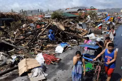 Người dân đi bên đống đổ nát sau khi bão Haiyan đi qua thành phố Tacloban, tỉnh Leyte, miền Trung Philippines ngày 10/11. (Nguồn: AFP/TTXVN)