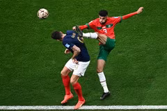 Pha tranh bóng giữa tiền đạo Pháp Olivier Giroud (trái) và hậu vệ Maroc Noussair Mazraoui. (Ảnh: AFP/TTXVN)