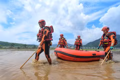 Lực lượng cứu hộ làm nhiệm vụ tại khu vực ngập lụt ở tỉnh Cát Lâm, Trung Quốc ngày 29/7. (Ảnh: THX/TTXVN)