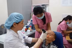Bác sỹ khám cho trẻ có dị tật ở môi. (Ảnh: PV/Vietnam+)