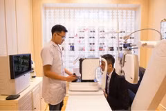 Chuyên viên khúc xạ kiểm tra thị lực cho khách hàng bằng máy đo khúc xạ. (Ảnh: PV/Vietnam+)