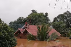 Người dân chờ cứu hộ tại vùng ngập lụt do sự cố vỡ đập thủy điện Xe Pian-Xe Namnoy ở Attapeu ngày 24/7. (Ảnh: THX/TTXVN)