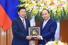 Thủ tướng Nguyễn Xuân Phúc tặng quà lưu niệm cho Thủ tướng Lào Thongloun Sisoulith. (Ảnh: Thống Nhất/TTXVN)