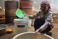 Bà Khuất Thị Sửu vẫn sử dụng nguồn nước này sinh hoạt hàng ngày dù biết nước có biểu hiện bất thường. (Ảnh: Phạm Cường/TTXVN)