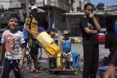 Người dân Palestine xếp hàng lấy nước sinh hoạt tại một trại tị nạn ở Dải Gaza. (Ảnh: AFP/TTXVN)