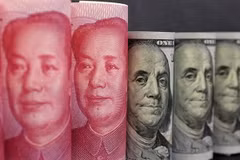 Đồng tiền giấy 100 Nhân dân tệ (trái) và đồng đôla Mỹ ở Bắc Kinh. (Nguồn: Reuters/ TTXVN)