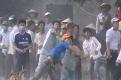 Giáo dân quá khich ném đá vào trụ sở Ủy ban Nhân dân xã Nghi Phương ngày 4/9/2013. (Ảnh: Chụp lại từ video clip. TTXVN phát)