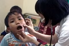 Một bệnh nhi ở xã Ba Điền, huyện miền núi Ba Tơ mắc "bệnh lạ" đang được các bác sỹ khám tại Bệnh viện đa khoa Quảng Ngãi. (Nguồn: Vnexpress)