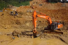 Sử dụng máy xúc đẩy nhanh tiến độ tìm kiếm. (Ảnh: TTXVN phát)