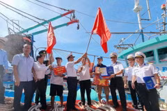 Bộ Tư lệnh Vùng 4 Hải quân tặng cờ Tổ quốc, áo phao và quà cho ngư dân tại cảng cá Mỹ Tân, xã Thanh Hải, huyện Ninh Hải, tỉnh Ninh Thuận. (Ảnh: Nguyễn Thành/TTXVN)