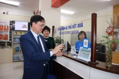 Ông Nguyễn Quang Trung, Chủ tịch UBND quận Hai Bà Trưng kiểm tra việc giải quyết thủ tục hành chính qua môi trường điện tử cho người dân tại phường Phố Huế. (Ảnh: Mạnh Khánh/TTXVN)