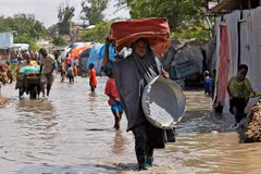 Người dân sơ tán khỏi vùng ngập lụt sau những trận mưa lớn tại Mogadishu, Somalia. (Ảnh: AFP/TTXVN)