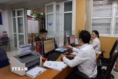 Cán bộ xã, phường giải quyết thủ tục hành chính cho người dân. (Ảnh: TTXVN)