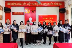 Đại diện giáo viên nhà trường tiếp nhận quà của em Phú. (Ảnh: TTXVN phát)
